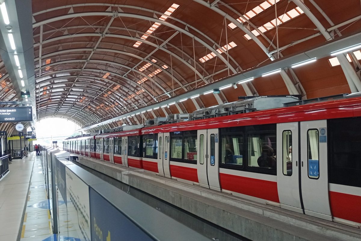 A red train waits at the modern station.