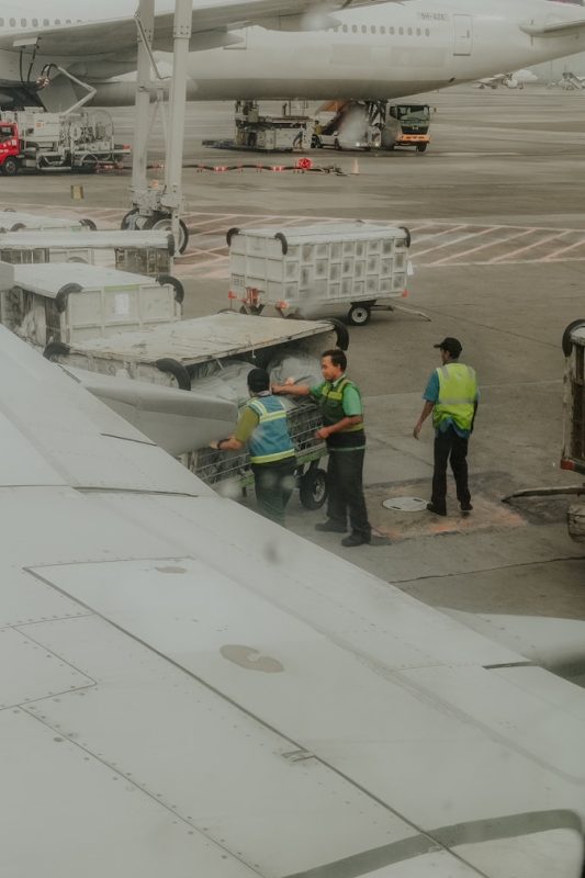 Ground crew loading baggage onto an airplane.